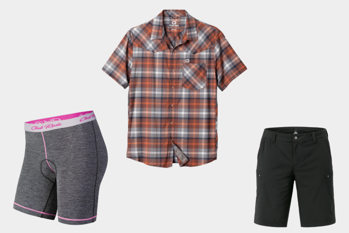 A set of outdoor clothing items, including a short-sleeve plaid button-up shirt in orange and gray tones, a pair of gray cycling shorts with pink trim, and a pair of black outdoor shorts. Each item is designed for comfort and functionality.
