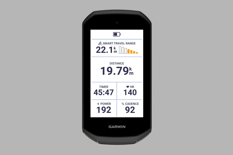 A Garmin cycling device display showing various statistics: smart travel range of 22.1 km, distance traveled of 19.79 km, timer at 45:47 minutes, heart rate at 140 bpm, power output of 192 watts, and cadence of 92 RPM. The screen features a battery indicator and a clean layout for easy readability.