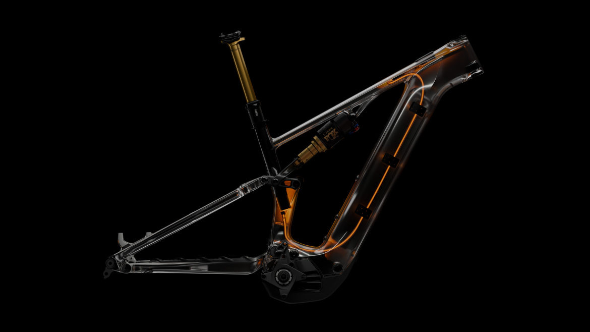 A transparent mountain bike frame showcasing internal components and suspensions, illuminated against a black background, highlighting the design and engineering features.