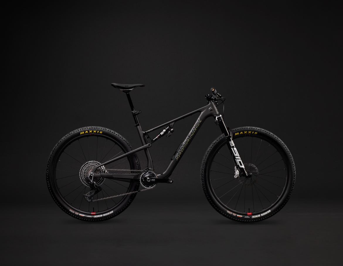 A sleek black mountain bike is displayed against a dark background, showcasing its lightweight frame, high-performance tires, and advanced components. The bike features prominent branding and modern design elements, emphasizing its suitability for off-road adventures.