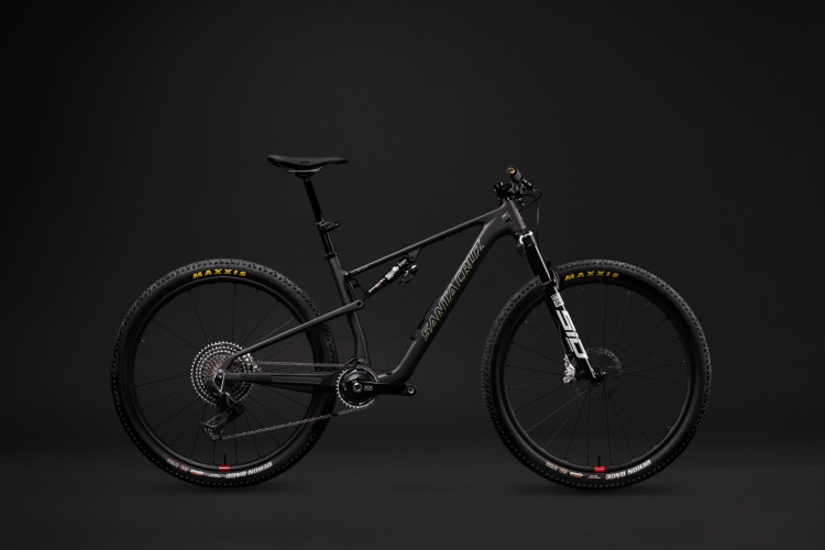 A sleek black mountain bike is displayed against a dark background, showcasing its lightweight frame, high-performance tires, and advanced components. The bike features prominent branding and modern design elements, emphasizing its suitability for off-road adventures.