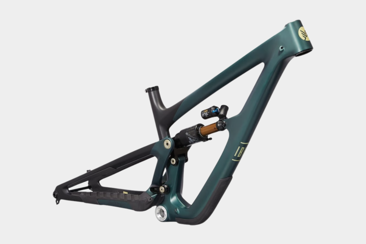 Image of a mountain bike frame in a dark teal color with a contrasting black rear triangle. The frame features integrated suspension components, including a shock, showcasing a modern design suitable for off-road biking.
