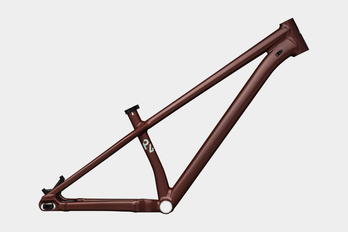 A bicycle frame displayed from the side, featuring a sleek design and a matte brown finish. The frame includes a bottom bracket, seat post, and head tube, with a visible logo in light color on the frame.