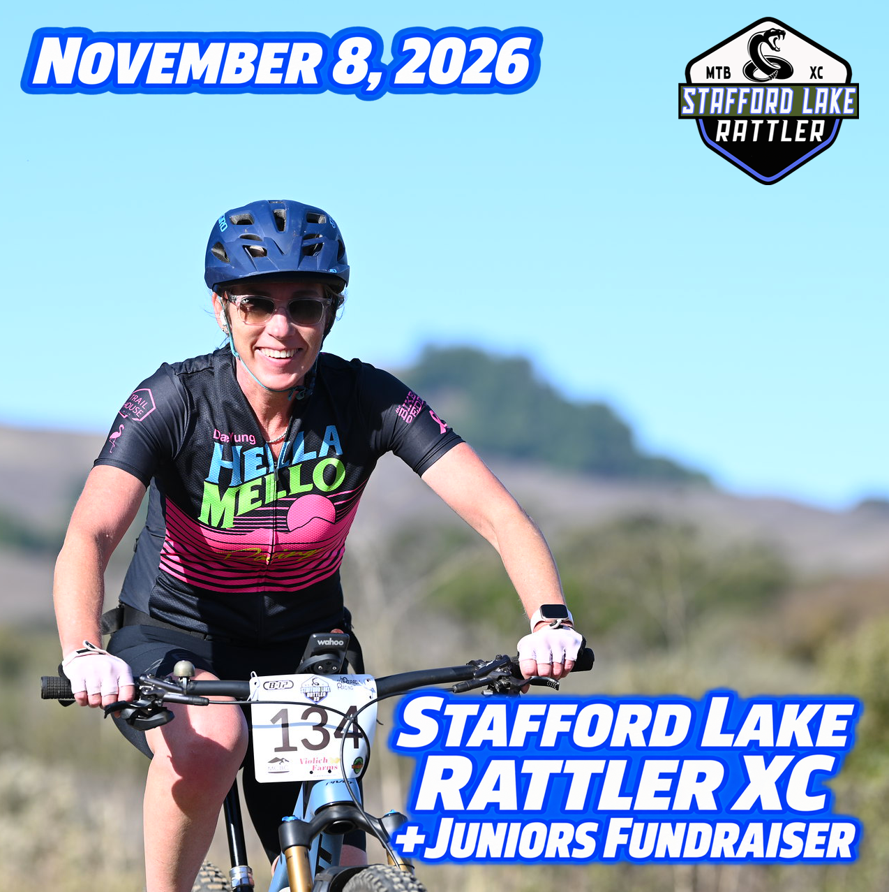 A smiling cyclist wearing sunglasses and a colorful jersey rides a mountain bike on a sunny day. The image includes text that reads "November 8, 2026," "Stafford Lake Rattler XC," and "+ Juniors Fundraiser," along with a logo in the corner. The background features a scenic view of hills and greenery.