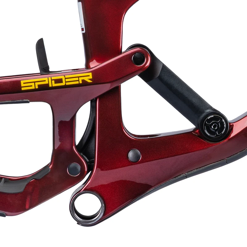 Close-up image of a bicycle frame highlighting the suspension linkage, featuring a glossy red finish with the word "SPIDER" in yellow lettering. The design showcases the intricate engineering and components used in mountain bike construction.
